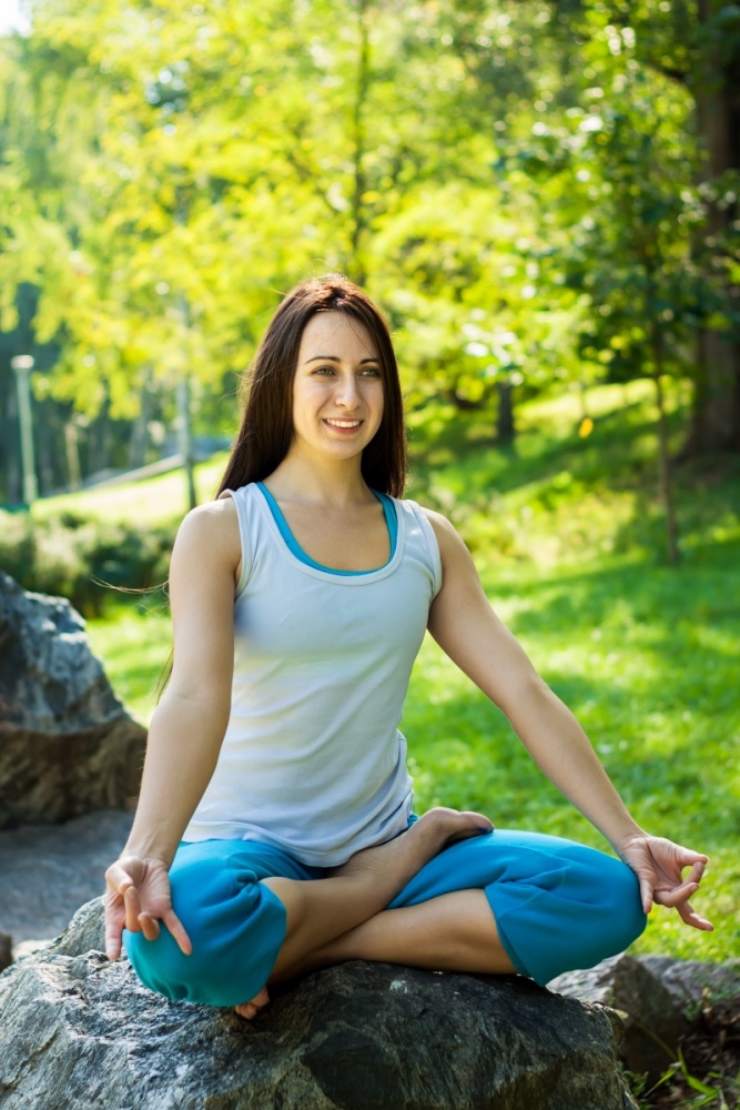 O femei sta in pozitie Lotus si practica Shunya Mudra