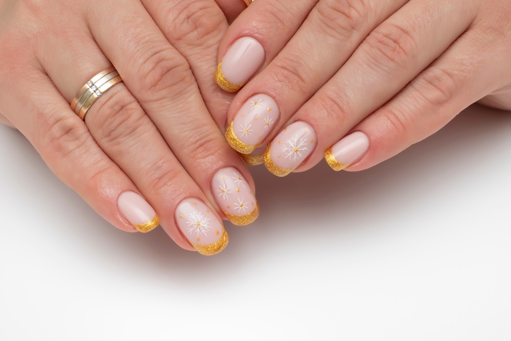 manichiura cu glitter auriu si fulgi de zapada pe unghii