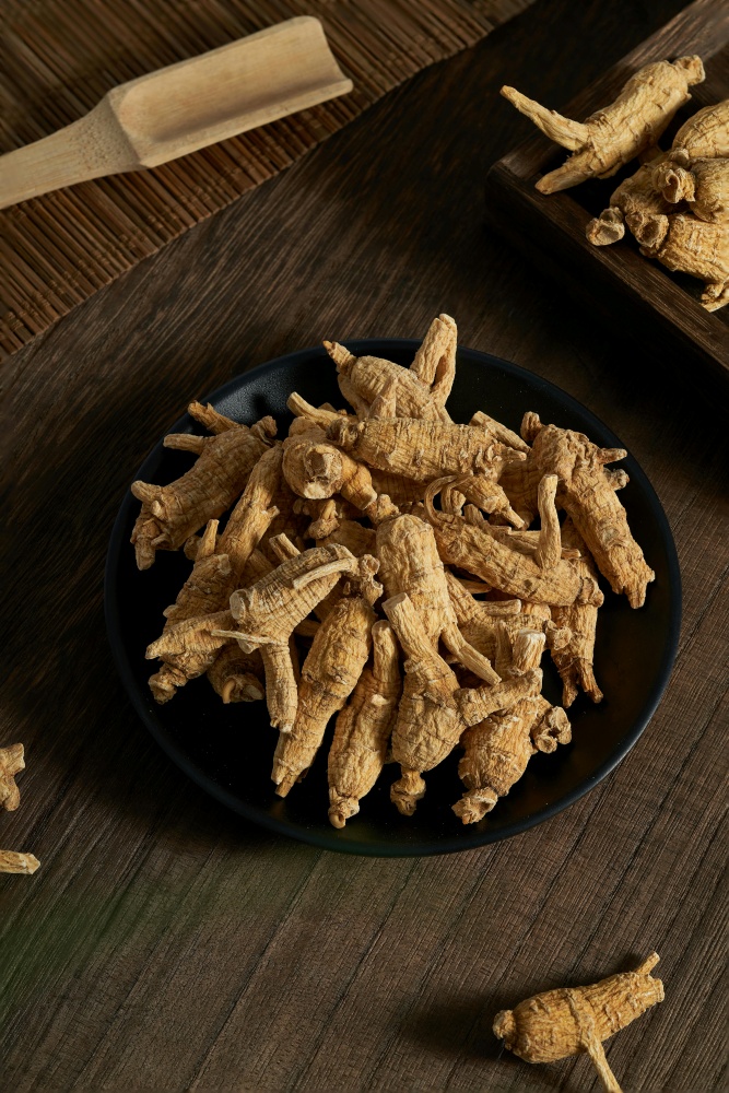 O masa pe care se afla un platou ce contine mai multe bucati de ginseng. Alte bucati sunt imprastiate pe langa.