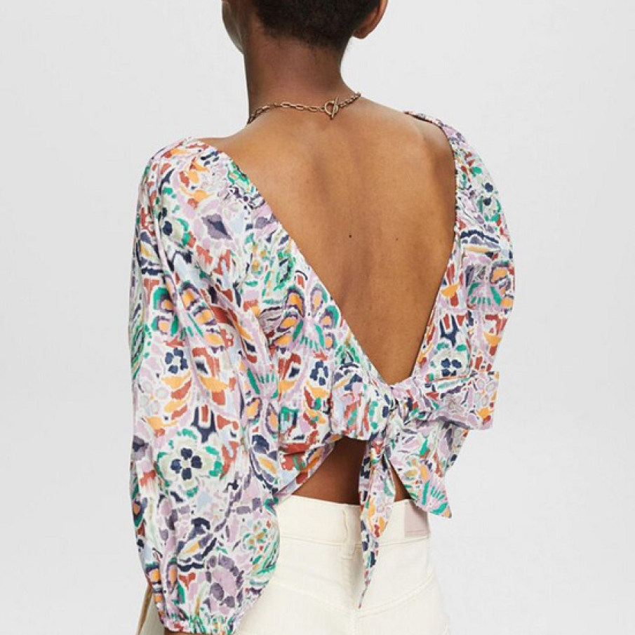 O bluză elegantă cu imprimeu multicolor abstract și decolteu amplu, în V, pe spate, care se termină cu o fundiță pentru un efect wow