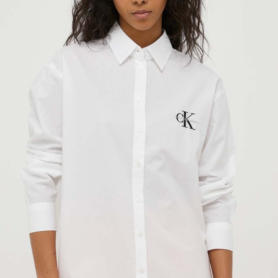 Cămașă albă din bumbac, clasică, by Calvin Klein Jeans. Are logo în piept, linia umerilor ușor căzută și mâneci lungi 