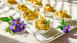Ouă umplute cu o pastă gustoasă preparată din gălbenuș de ou, cremă de brânză, turmeric și decorată cu salată de untișor 