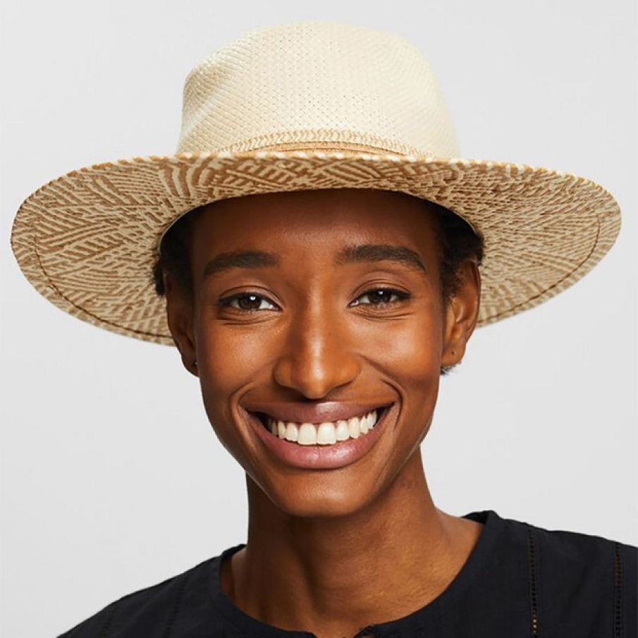 Pălărie bej deschis din paie, cu imprimeu parțial, într-un ton de bej mai închis la nivelul borurilor. 