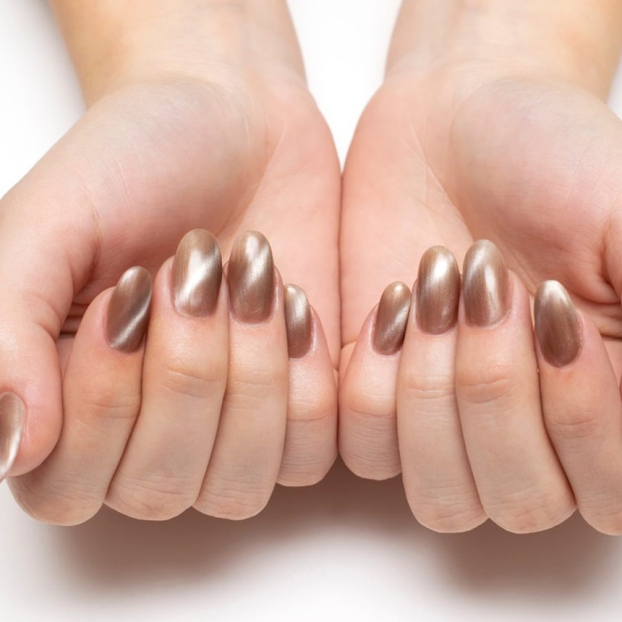 Manichiura Ochi de pisică în care predomină bejul cafeniu, iar reflexele de lumină sunt descrise de alb. 