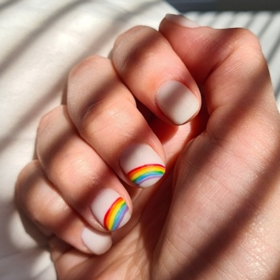 Manichiură nude cu design de curcubeu pe două unghii 