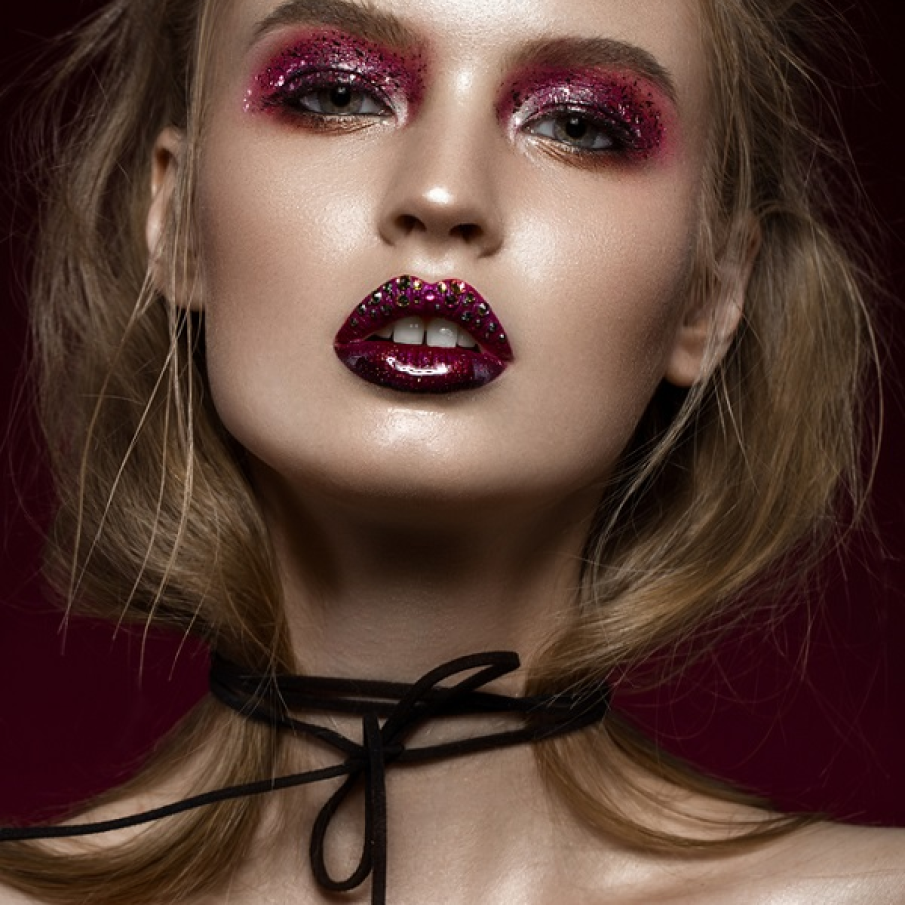 Strălucitorul a fost dus până aproape de extreme în 2022, iar mini bijuteriile aplicate, ștrasurile colorate și mini cristalele strălucitoare împodobesc deseori și buzele sau doar buza superioară ca în ilustrația de mai sus