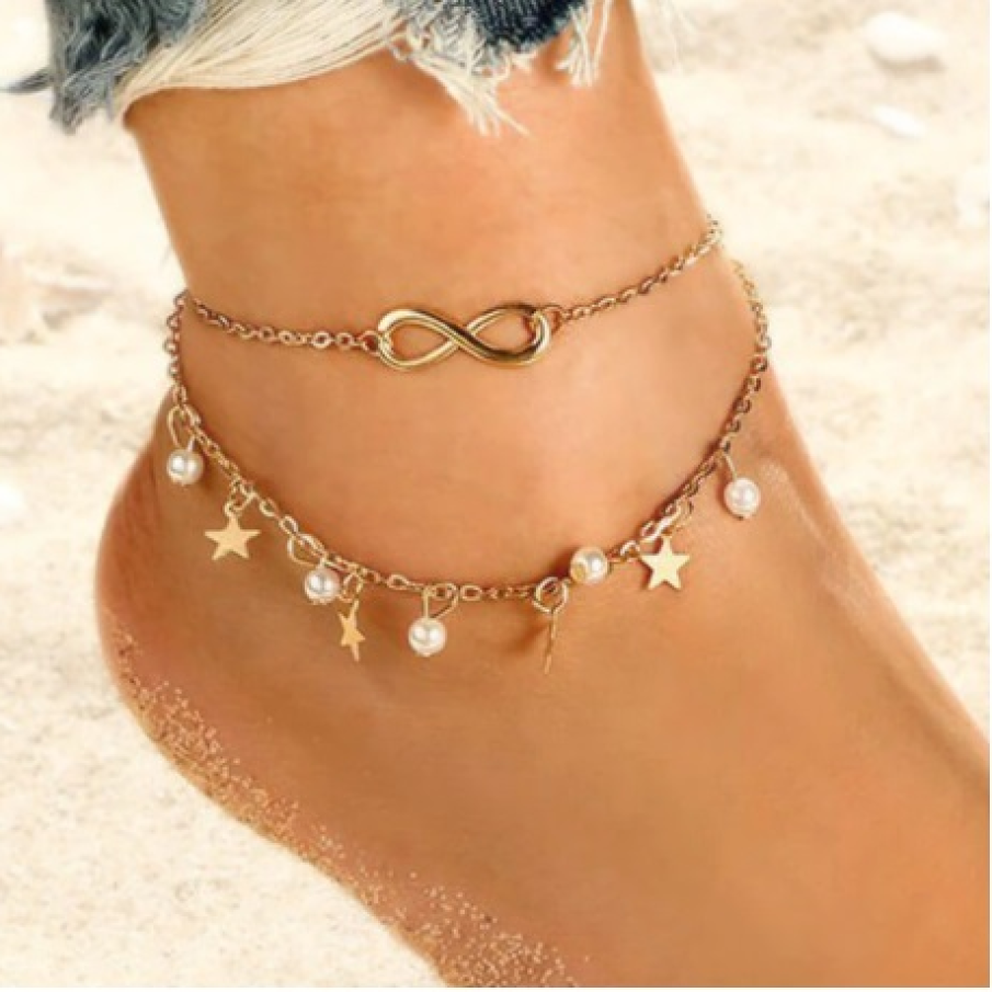 Brățară de picior dublă, cu simbolul infinitului (semnifică armonia, vitalitatea și bunăstarea) și miniaccesorii suspendate precum perle și steluțe 
