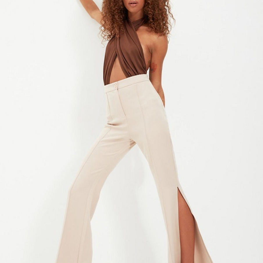 Pantaloni evazați, cu talie înaltă și două șlițuri îndrăznețe și proeminente, într-o culoare văratică de bej nisip. 