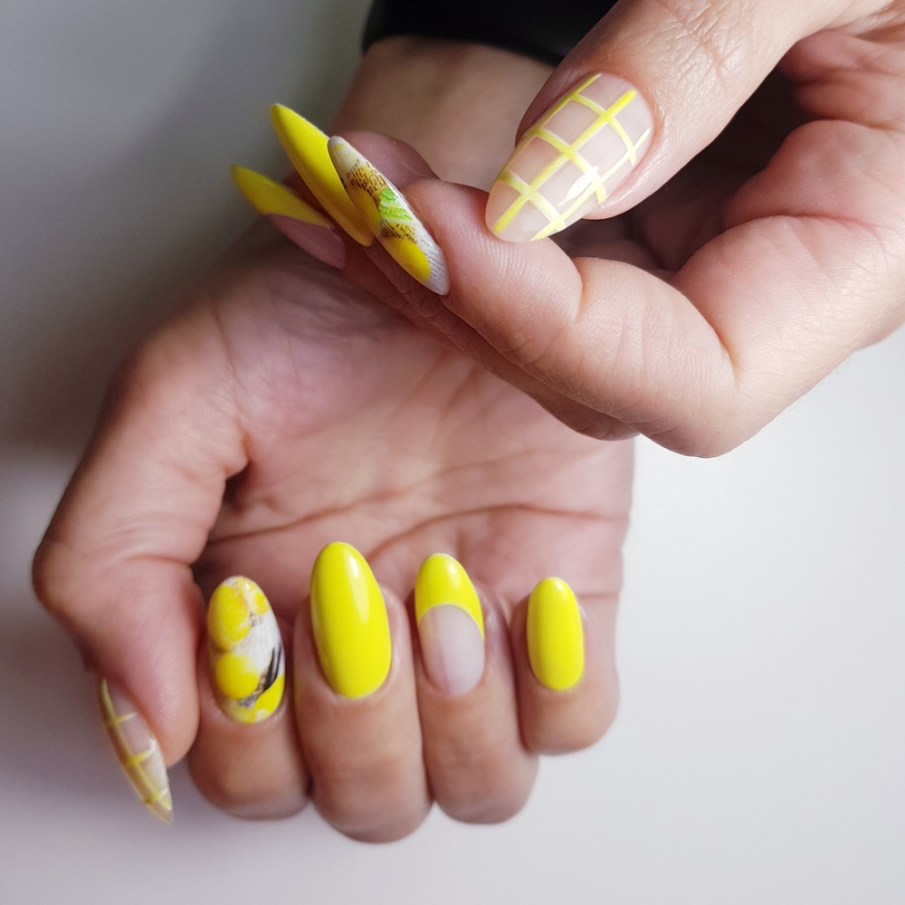 Manichiură galben aprins care combină manichiura franțuzească cu cea geometrică și cu print