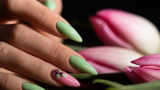 Manichiură de primăvară-vara în nuanță de roz și verde deschis, cu o floare cu ștras ca motiv floral pe unghia inelarului