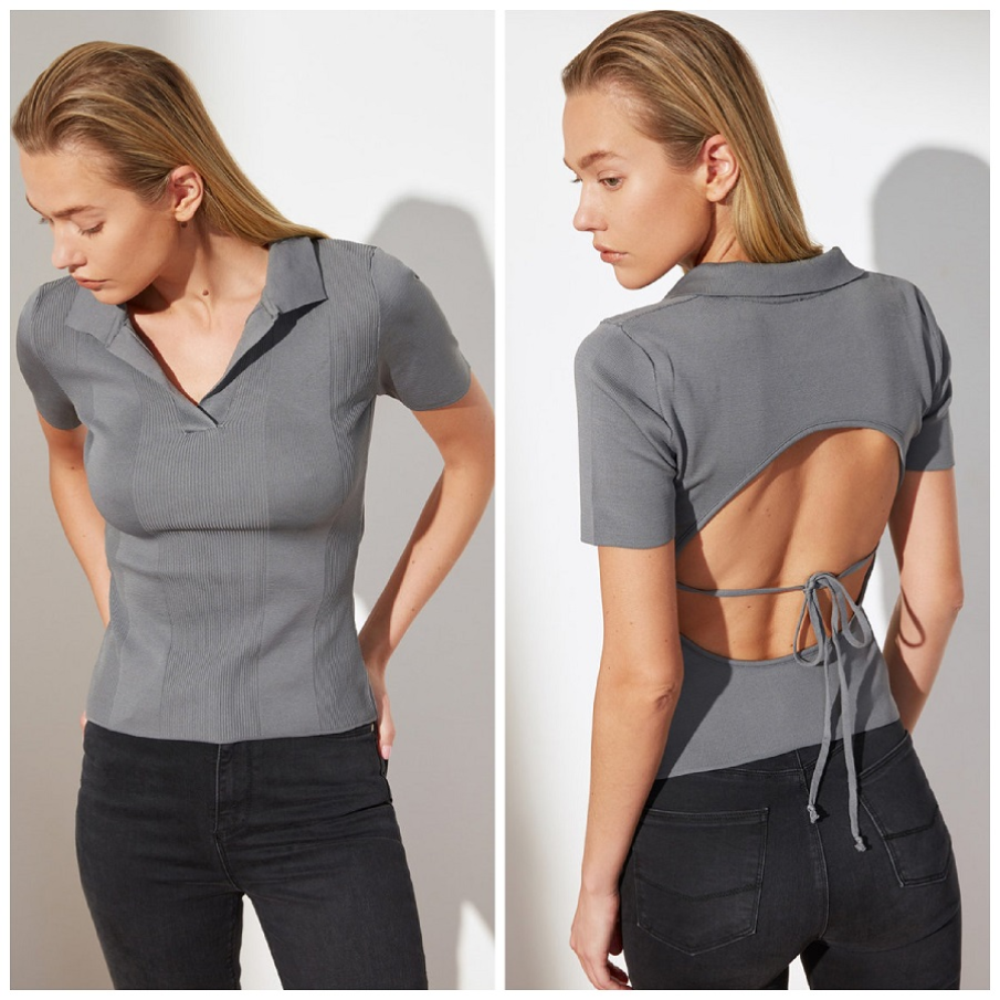 Bluza gri polo cu mâneci scurte și decupaj pe spate, dezgolind parțial această zonă a corpului 