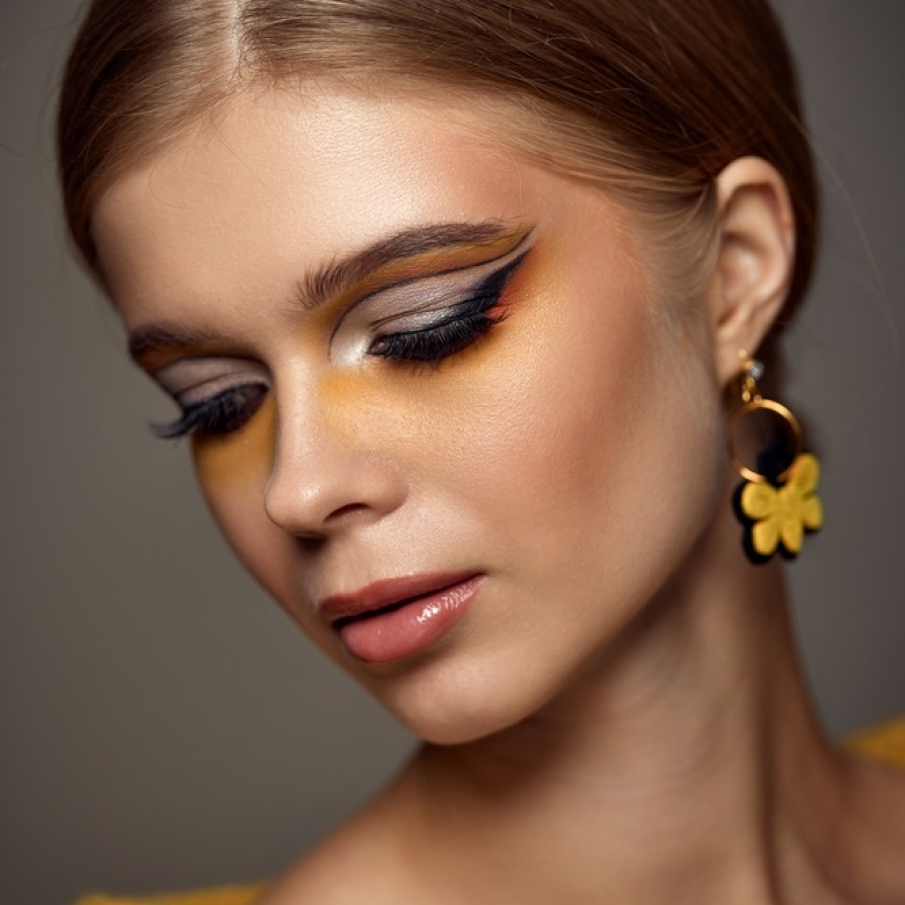 Machiaj în nuanță de galben stins cu accente grafice create cu ajutorul eye-linerului 