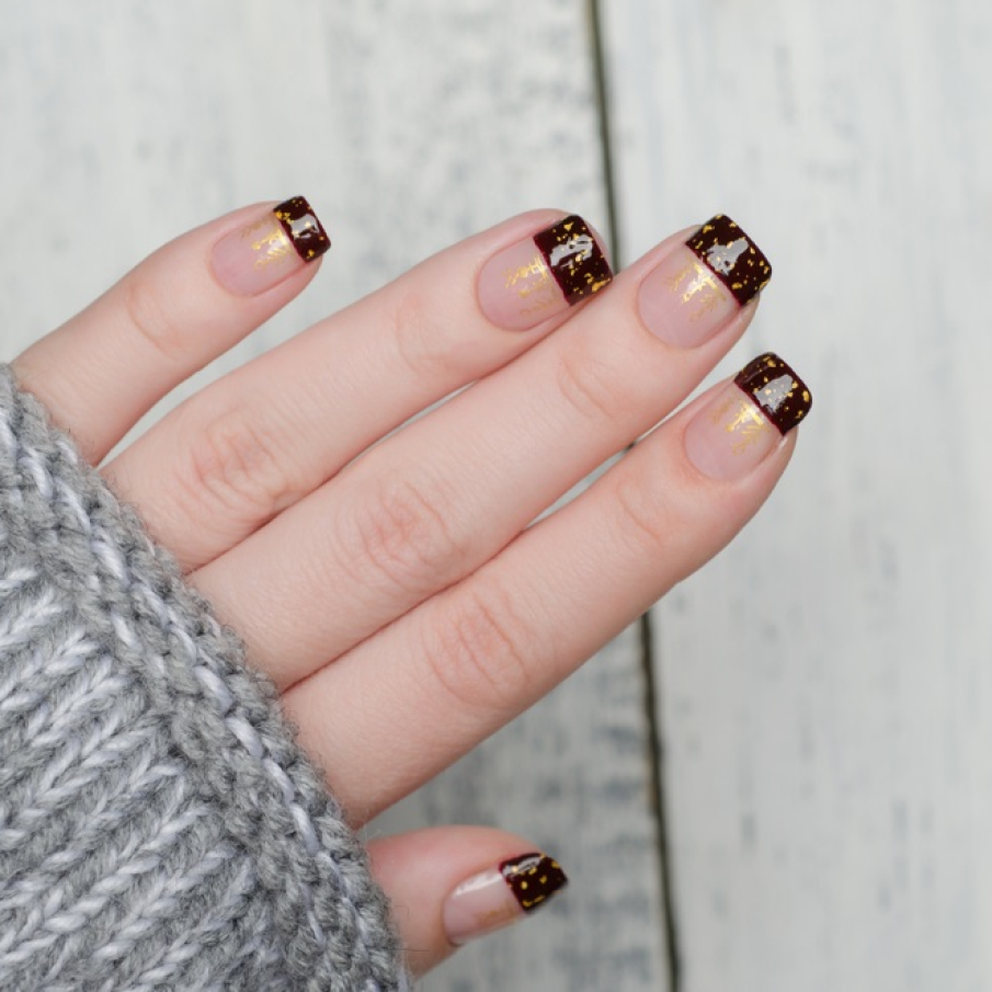 Manichiură french pătrată, cu vârfurile înmuiate în roșu dramatic, decorat cu sclipiri aurii 