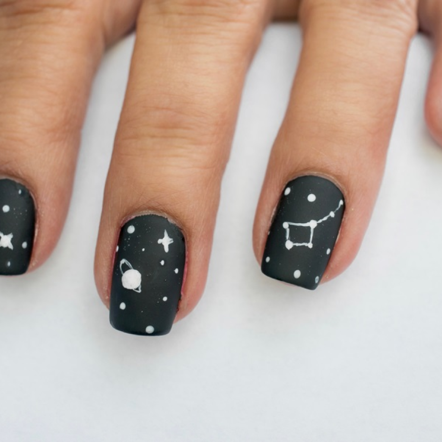 Manichiură neagră mată și simplă, cu stele și planete pictate pe unghii 