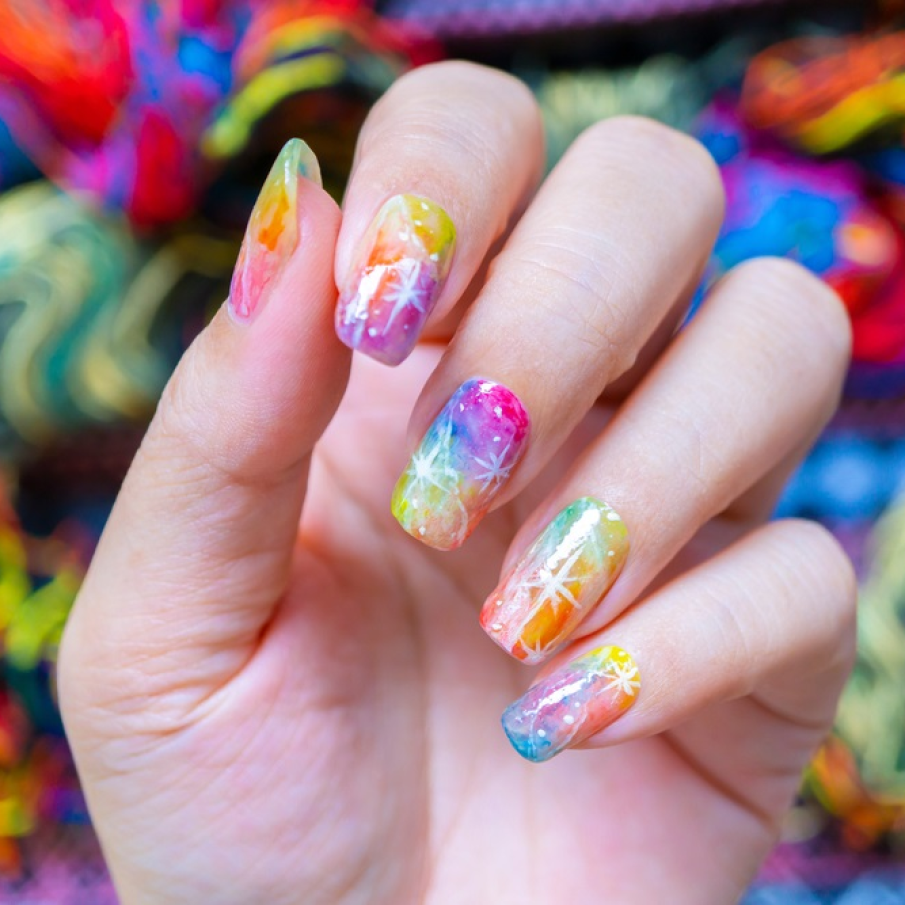 Manichiură galaxy cu gel, în nuanțe viu colorate, cu detalii cosmice și efect translucid