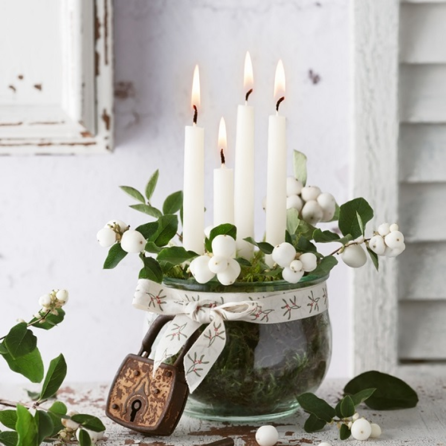 Un borcan spațios umplut cu 4 lumânări înalte, fructe albe și crenguțe de hurmuz alb. Îmbracă marginea borcanului cu o panglică tematică de Crăciun, de preferat a păstra această cromatică albă predominantă