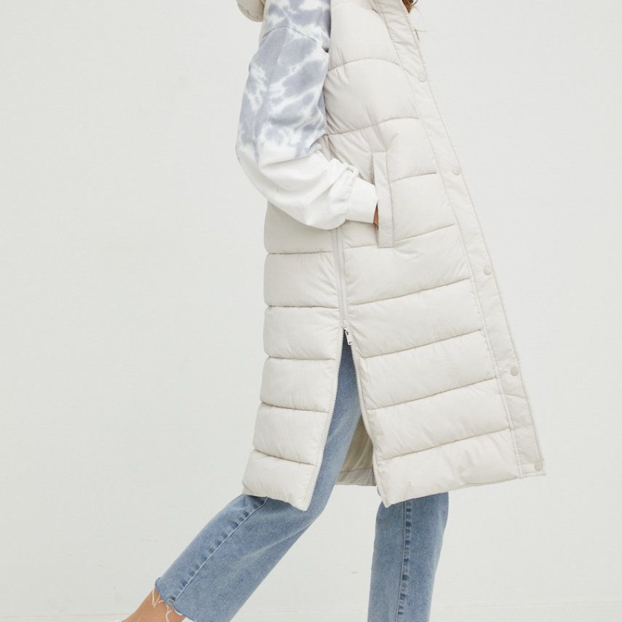 Vestă albă de iarnă din colecția Answear Lab, cu aspect matlasat. Are glugă detașabilă și este izolată cu căptușeală. 