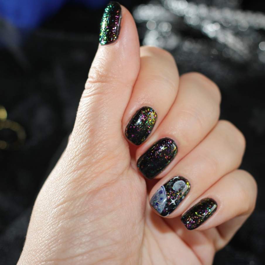 Manichiură neagră cu glitter multicolor și un efect spectaculos care și-a propus să redea Calea Lactee 