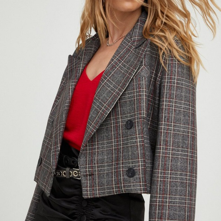 Sacou gri scurt, în carouri, cu un singur rând de nasturi. Are linia umerilor lăsată și clapetă.