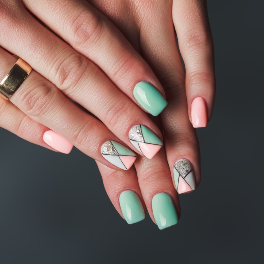 Design geometric de unghii în nuanțe de roz și verde, cu accente de argintiu