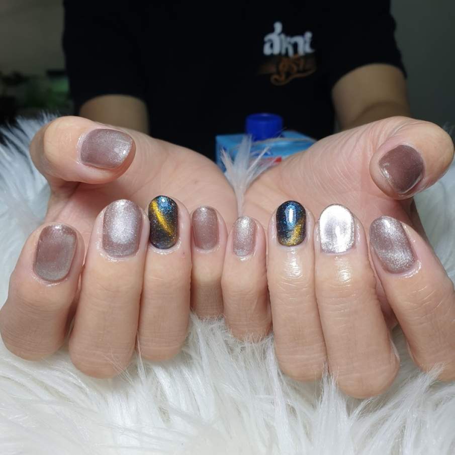 Manichiură cu reflexe metalizate intense și detalii ce țin de spațiu 