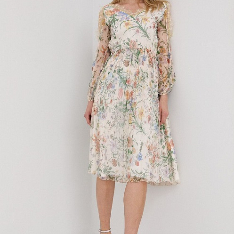 O rochie Nissă diafană și feminină, cu un imprimeu floral delicat și inserții decorative la baza gâtului. Materialul exterior este confecționat 100% din mătase. 