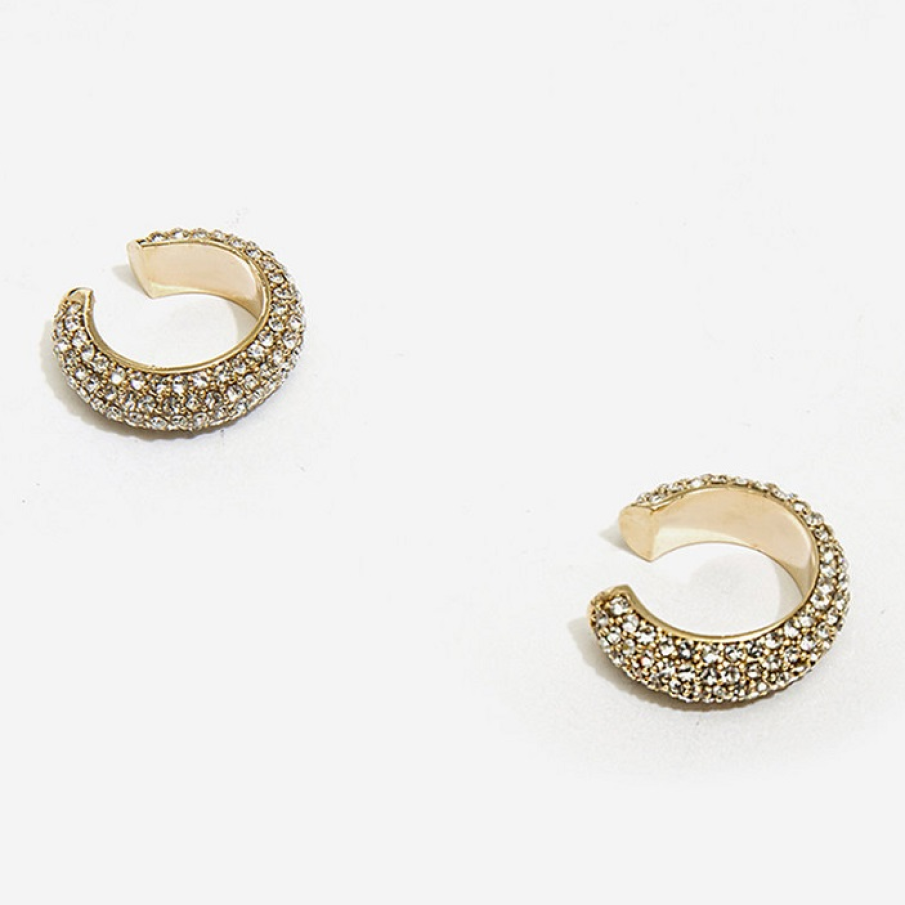 Cercei rotunzi decorați cu cristale, cu aspect glamorous, pentru un look elegant și sofisticat. Sunt confecționați din alamă.