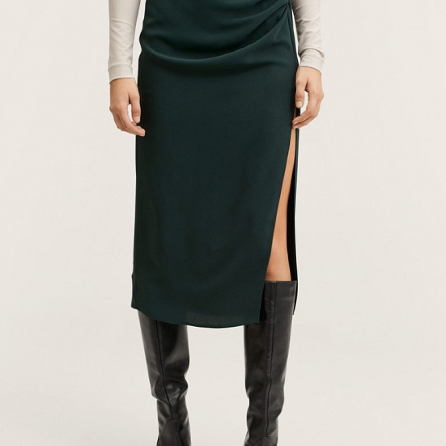 Fustă Mango cu o crăpătură provocatoare și talie înaltă, încrețită. Culoarea fustei este un verde englezesc profund și potolit. 