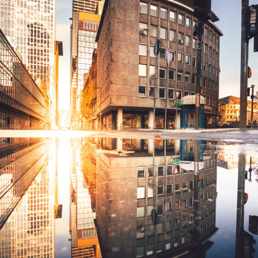 Frankfurt în zorii zilei, văzut pe suprafața unei băltoace de apă 