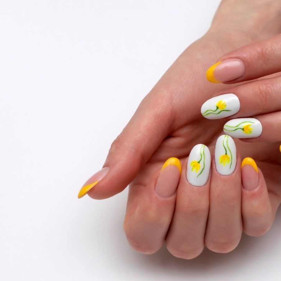 Manichiură franțuzească cu vârfurile de un galben solar și unghiile albe, cu model cu lalele