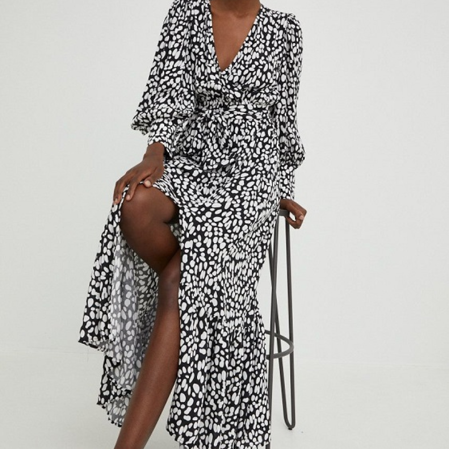 Rochie maxi din țesătura ornamentală alb-negru. Dispune de mâneci cu manșete, decolteu petrecut și sliț adânc.