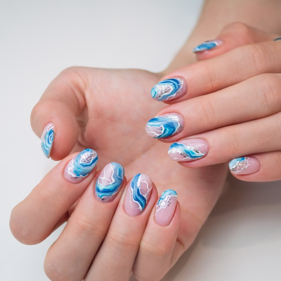 Manichiură cu gel, ojă și glitter care redă valurile înspumate ale mării în zilele lungi de vară