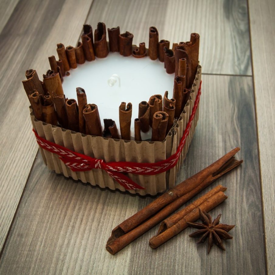 Lumânare handmade în suport de bețe de scorțișoară și carton decorat cu panglică 