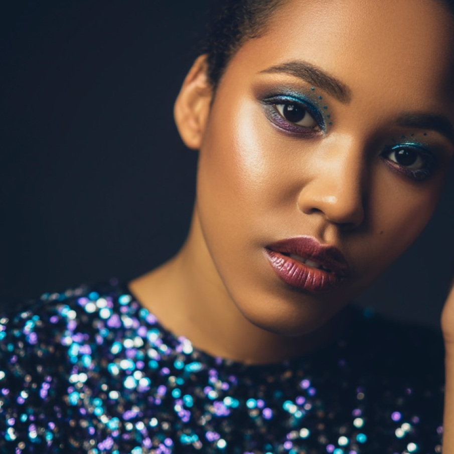 Machiaj pentru ochi negri pe bază de fard albastru strălucitor și mov. Pentru un plus de glamour, puteți apela și la câteva aplicații în aceeași nuanță de albastru metalic