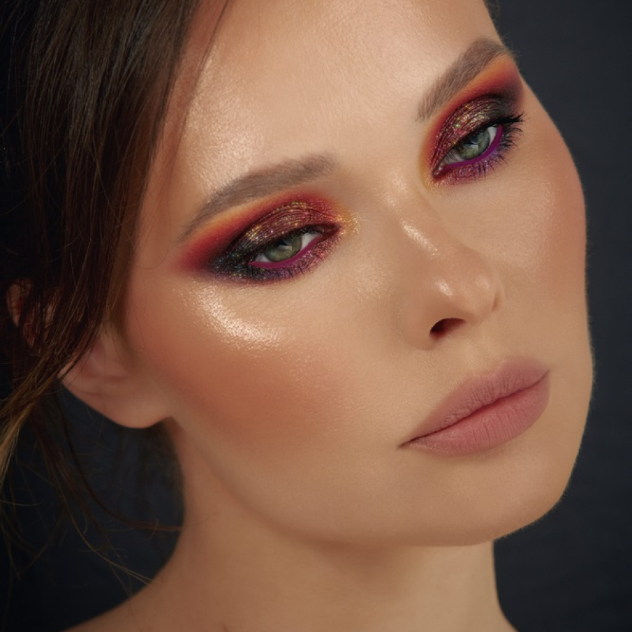 Machiaj de Crăciun dramatic tip smokey, cu pielea tenului cu accente de bronz și un machiaj al ochilor cu particule strălucitoare de glitter