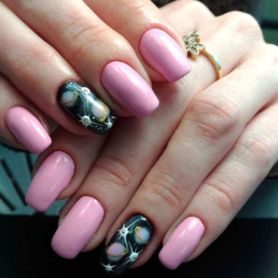 Manichiură roz cu detalii cosmice pictate și aplicate pe unghia inelarului 