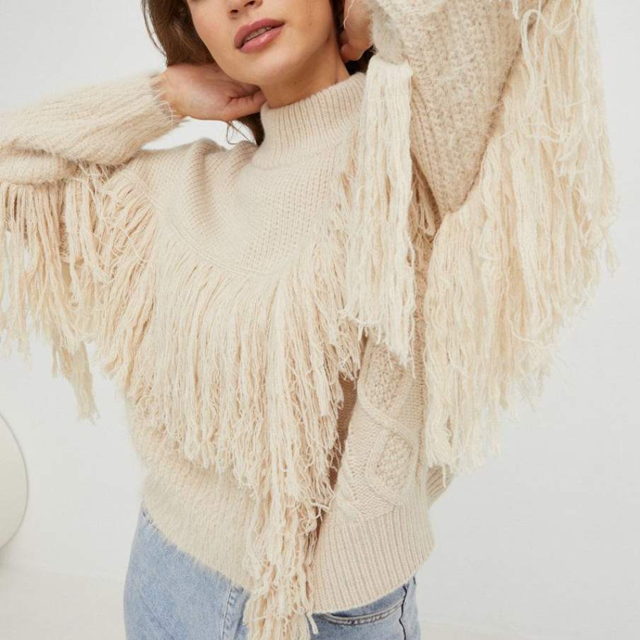 Pulover bej călduros, tip turtleneck, cu 20% Lână și ciucuri decorativi. Este perfect pentru zilele friguroase de iarnă. 