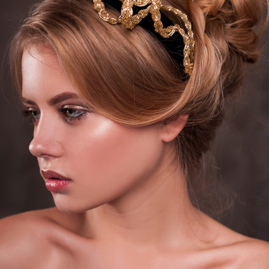 Bijuterii aurii și prețioase de păr, suprapuse peste o bentiță neagră, simplă 