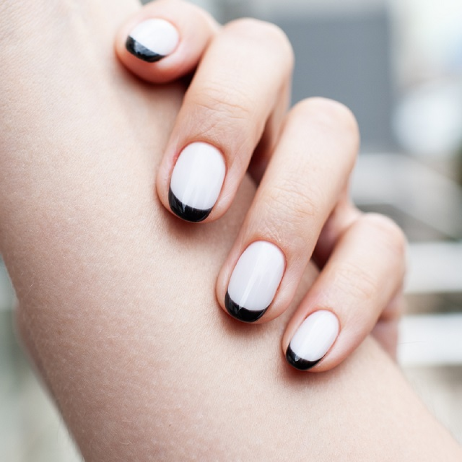 Manichiură în stil french minimalist, cu vârfurile negru catran și baza de alb lăptos 