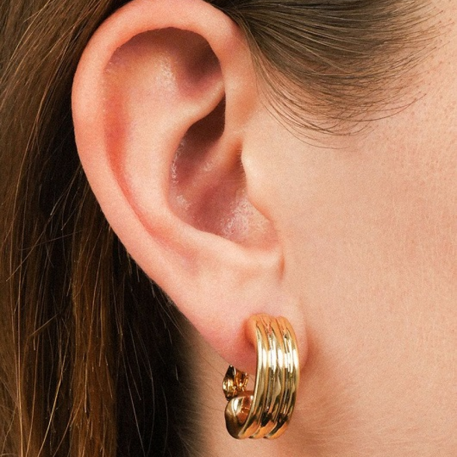 Cercei aurii Lauren Ralph Lauren, în stil clip on. Sunt confecționați din metal și au un aspect modern și sofisticat. 