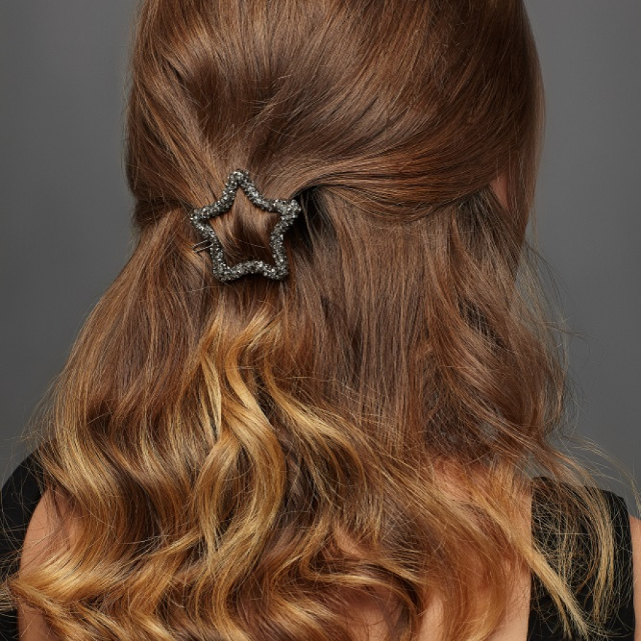 Cu un accesoriu stea argintiu si o coafura 