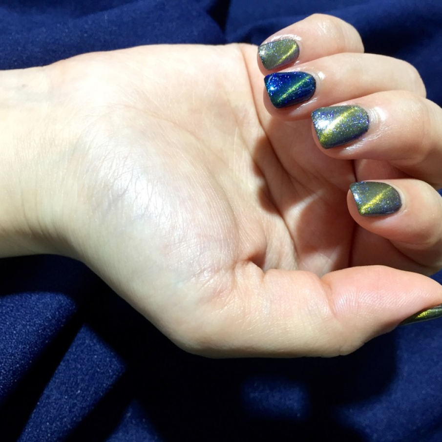 Manichiură Ochi de pisică cu dungi aurii de lumină trasate pe diagonala unghiei