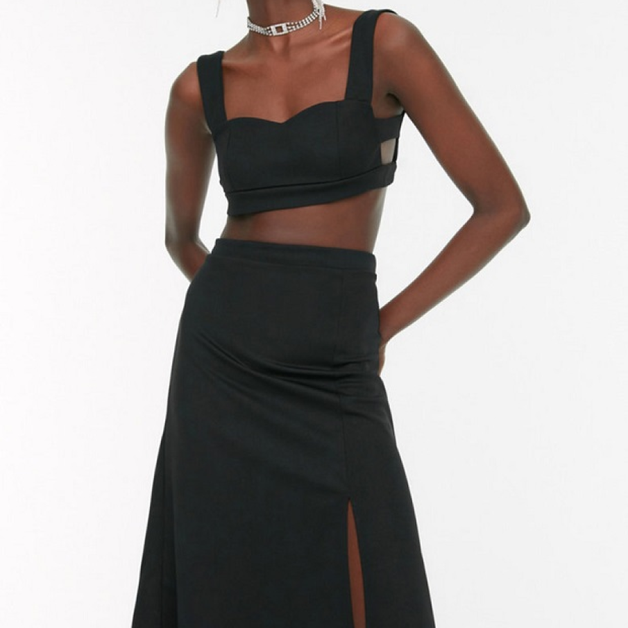 Set format din două piese: top scurt, cu decupaje, și fustă cu șliț parțial