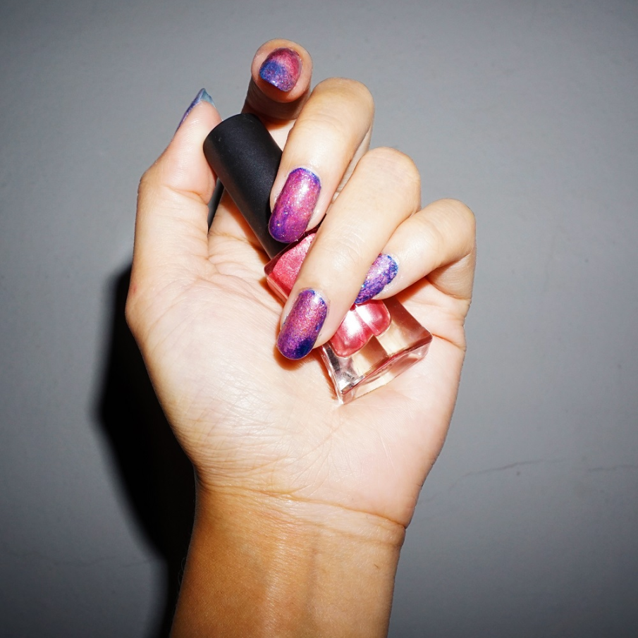 Manichiură cu glitter colorat și strălucitor, având ca tematică generală cosmosul 