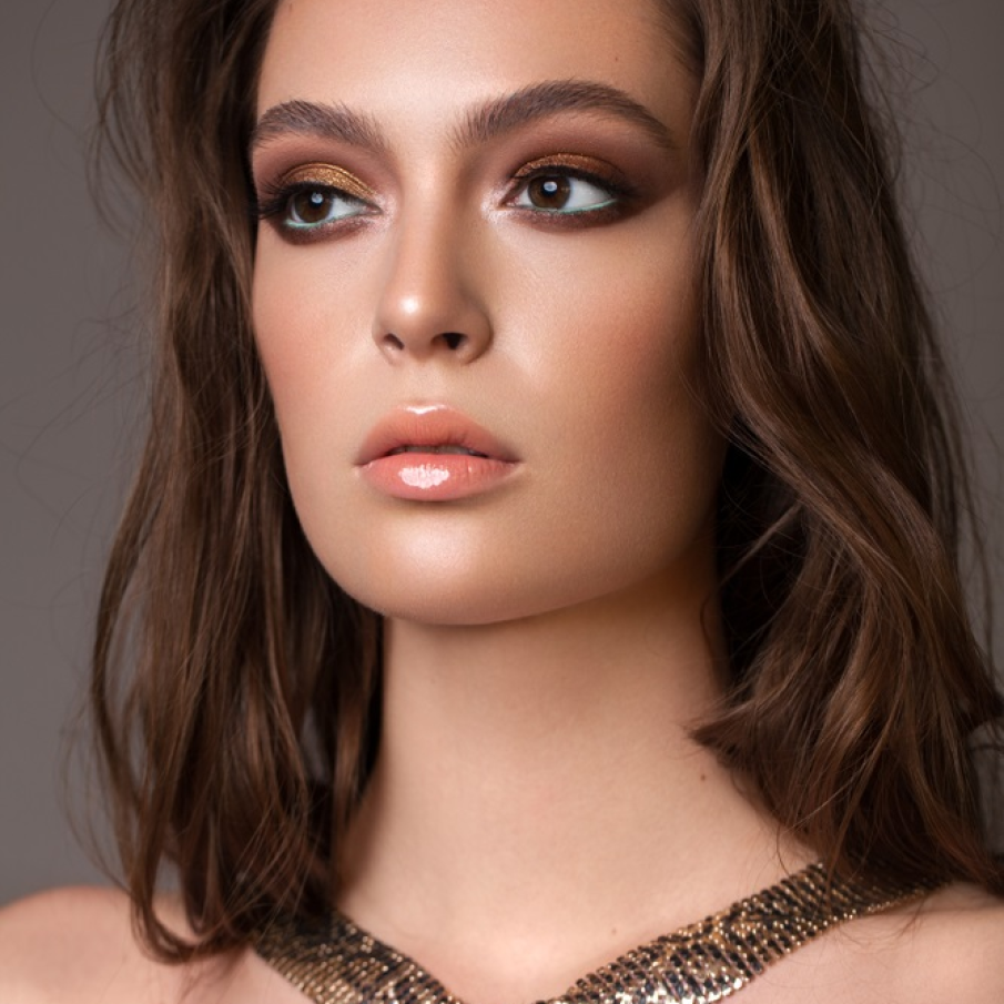 Machiaj auriu de Crăciun, cu sprâncene ușor ”ciufulite”, buze nude și senzuale fardate cu gloss și eyeliner verde pe pleoapa inferioară