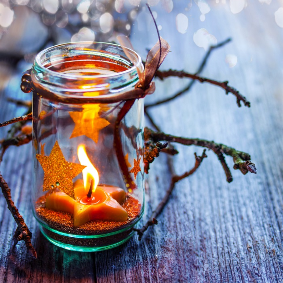 Decoratiunea perfectă de Crăciun: lumânare în formă de steluță într-un borcan decorat cu steluțe lipite pe suprafața lui 