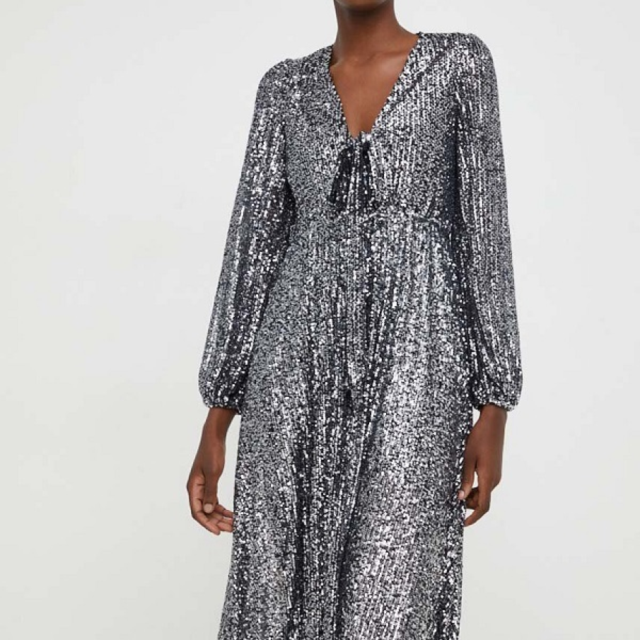 Rochie midi argintie cu efect de strălucire intensă, cu mâneci finisate cu bandă elastică. Se potrivește diverselor ocazii speciale 