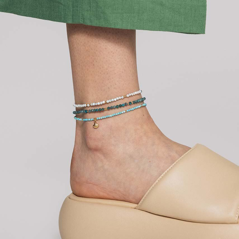Brățară de glezna din colecția ANIA KRUK, confecționată din argint placat cu aur 24k. Este decorată cu pietre naturale și elemente decorative tip mărgele în paletă de albastru  