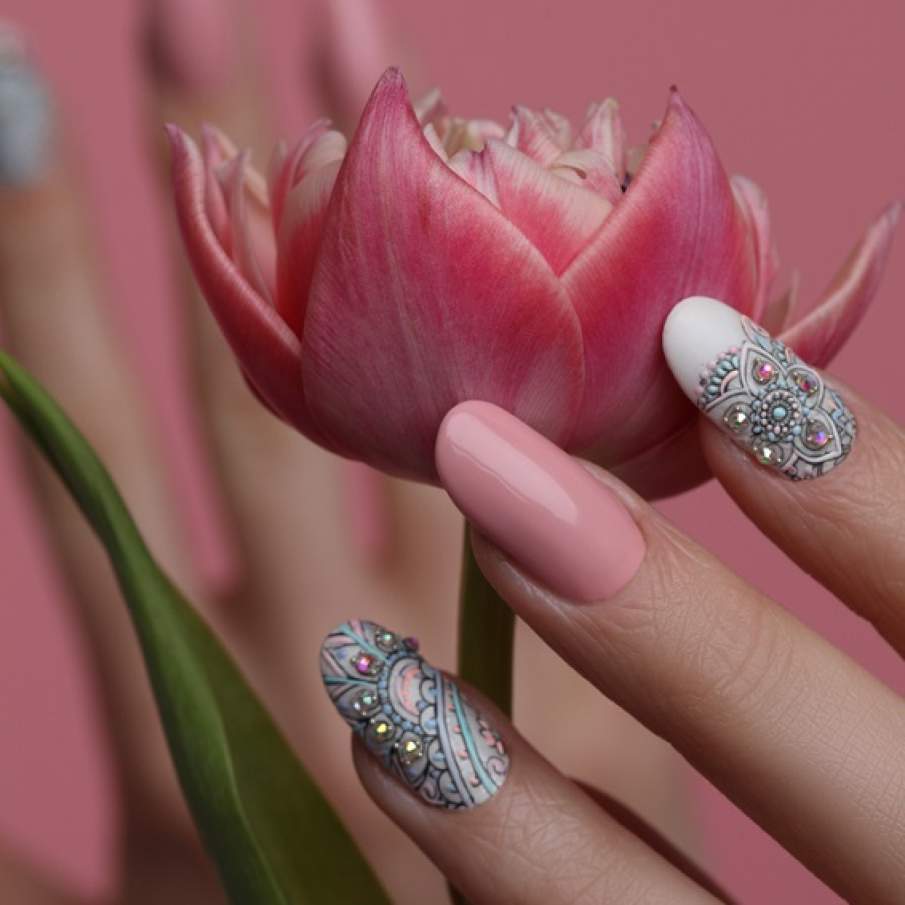 Nail art inspirat de primăvară cu modele elaborate și complexe pe unghiile arătătorului și ale inelarului 