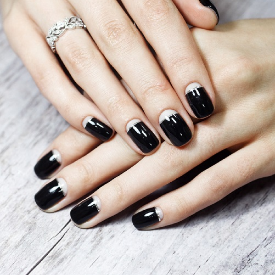 O manichiură elegantă și modernă cu negru profund și spații goale la baza unghiei 